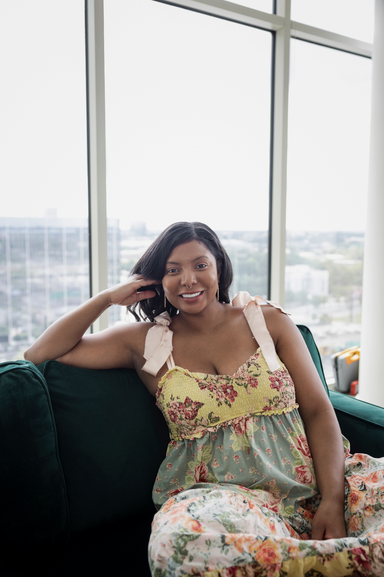 Ashleigh Evans seated on a deep green sofa