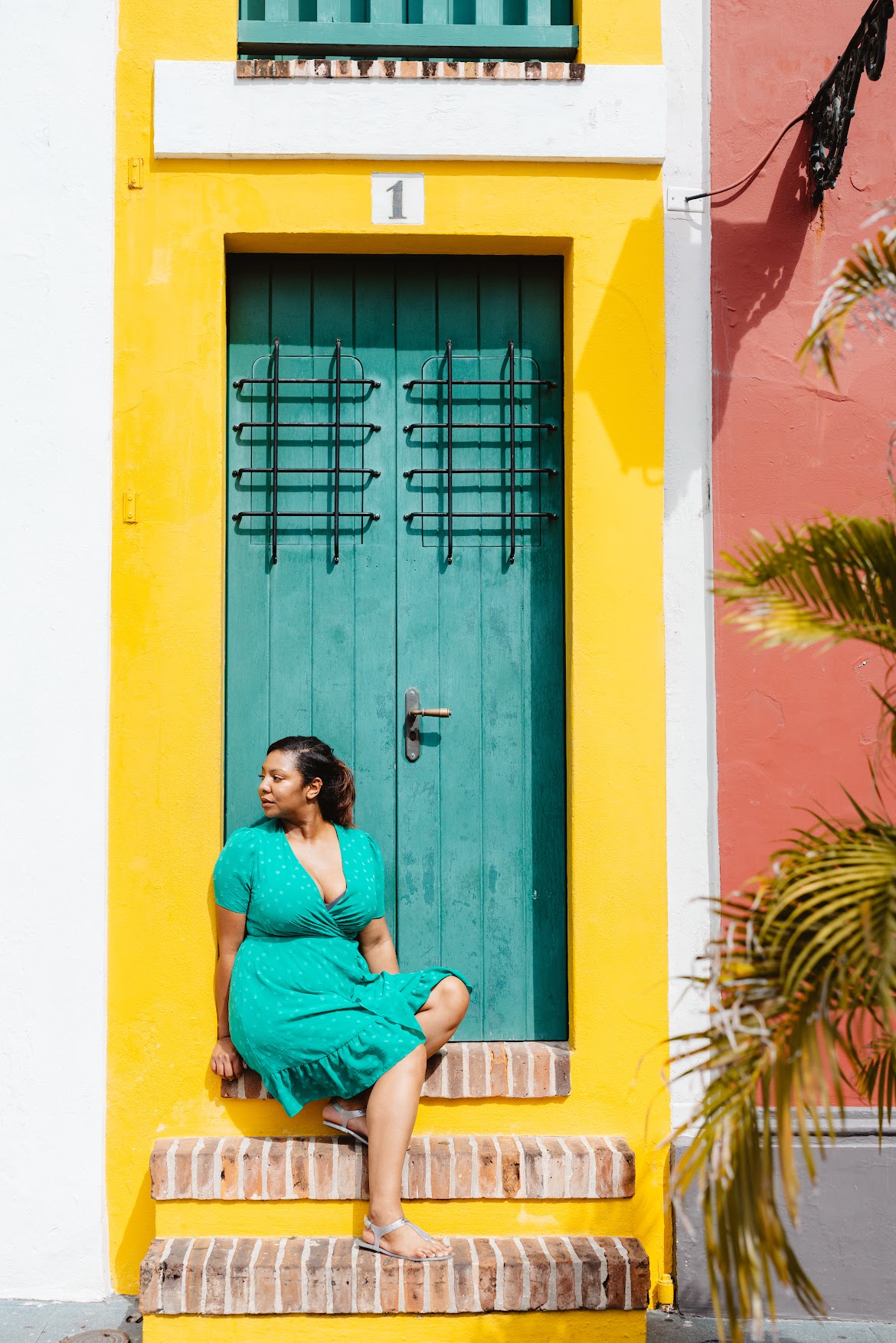 Ashleigh Evans in a green dress on colorful steps in San Juan